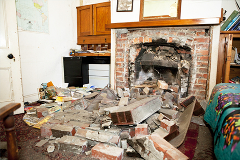 Damage in a lounge room from a collapsed brick chimney