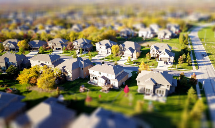 Long view of suburban street with large houses and sections